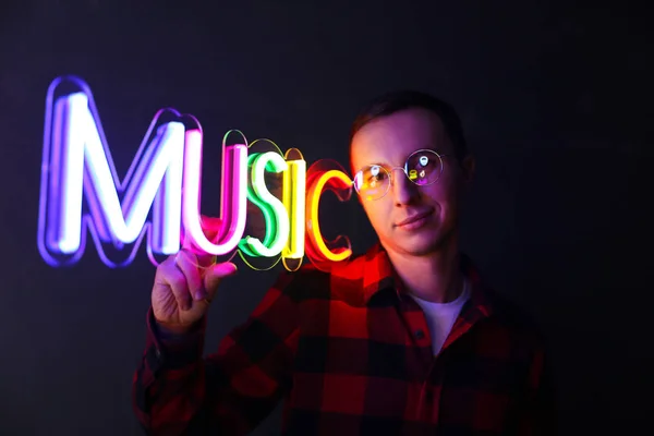 Hipster, gutaussehender Mann mit Leuchtreklamen. Bunte Leuchtreklame-Musik. — Stockfoto