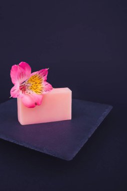 Siyah arka planda el yapımı sabunlar ve çiçekler. Deri bakımı konsepti. Güzellik. Doğal sabun yapımı. Sabun barları kapanıyor.. 