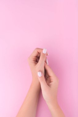 Pembe arka planda manikürlü güzel bir genç kadın eli. Düz yatış stili. Üst Manzara. Tasarım için yer. 