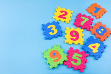 Renkli çocuklar mavi arka plandaki oyuncakları numaralandırır. Eğitim konsepti. Yaratıcı bir kavram. Düz konum, boşluk kopyala, üst görünüm.