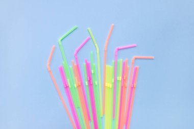 Mavi arka planda renkli plastik pipetler. Kokteyl tüpleri. Mesajın için yer aç. Plastik cerrahi olmasın. Plastiksiz konsept.