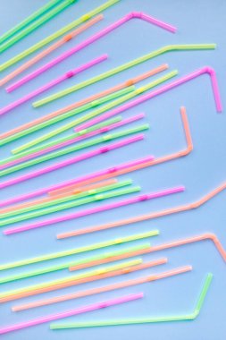 Mavi arka planda renkli plastik pipetler. Kokteyl tüpleri. Mesajın için yer aç. Plastik cerrahi olmasın. Plastiksiz konsept.