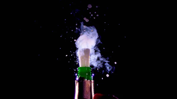 Champagne fires a powerful pressure from the neck of the bottle on a black background