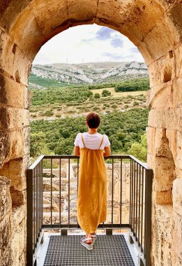 Bir kadın eski bir terastan manzaraya hayran..