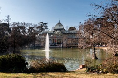 Madrid, İspanya. Jan 2020: Gölün önündeki Palacio de Cristal binası ve Parque del Retiro 'daki çeşme