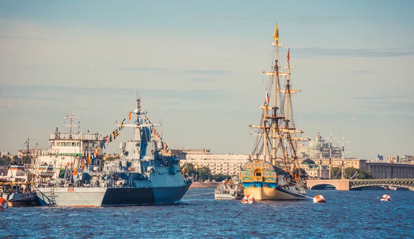 St Petersburg, Ryssland - 23 juli 2019 - Ryskt örlogsfartyg och segelbåt vid firandet av flottans dag — Stockfoto