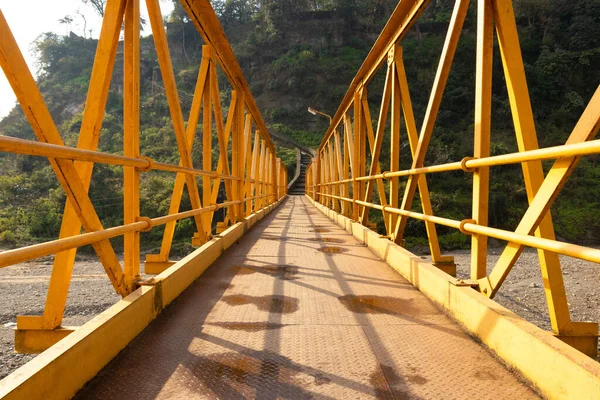 Kangra bölgesindeki Himachal Pradesh nehrinin üzerindeki sarı çelik köprü.