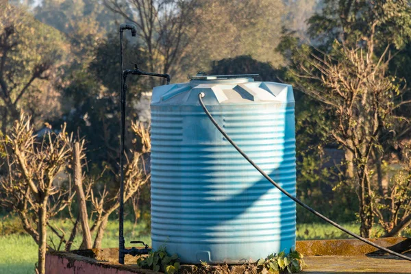 Blue water tank placed on the terrace of house connected with st
