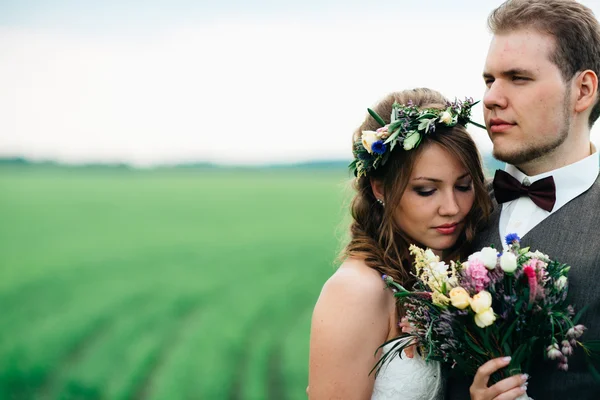 新娘和新郎在绿色的田野一束的肖像 — 图库照片