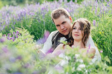 Gelin ve damat bir lavanta arka plan üzerinde dinlenme portresi