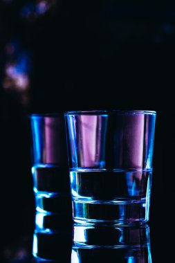Karanlık bir arka planda yakın plan içki bardakları.