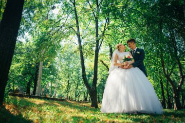 Gelin ve damat parkın arka planında.
