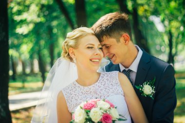 Gelin ve damat parkın arka planında.