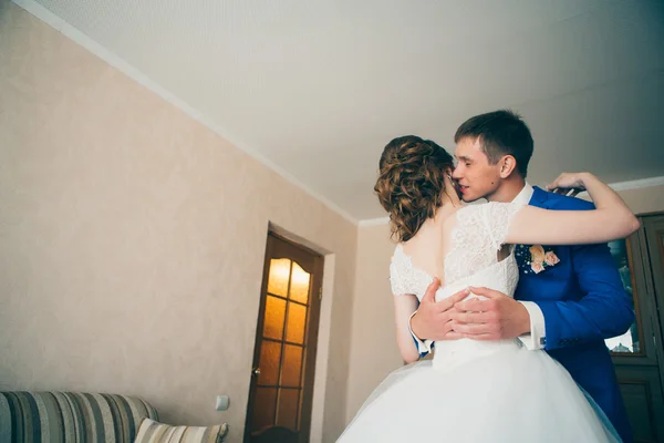Fiatal menyasszony és vőlegény ölelkezve a háttérben otthon — Stock Fotó