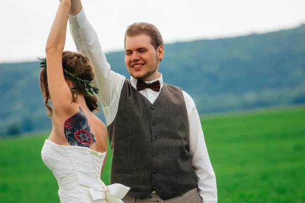 Portrét nevěsty a ženicha s kyticí na zelené louce — Stock fotografie