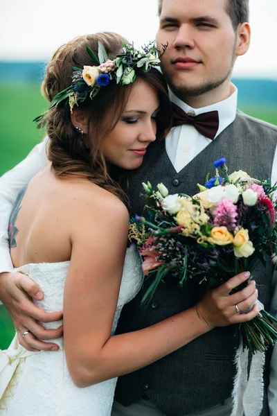 Portrait de la mariée et du marié avec un bouquet sur le champ vert — Photo