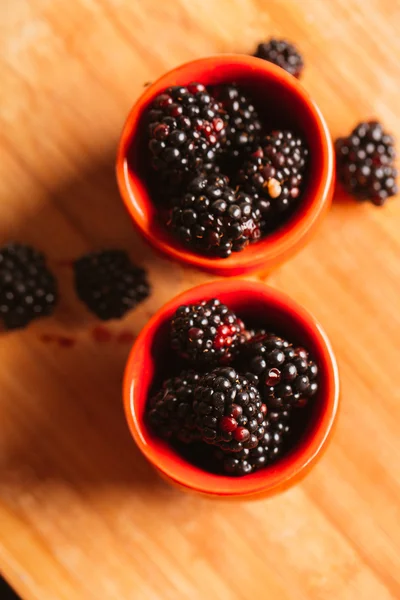 Blackberries in a cup on blurred background of wooden planks — Stock Photo, Image