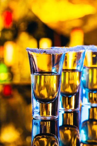 Stack of tequila with salt close up on blurred background — Stock Photo, Image