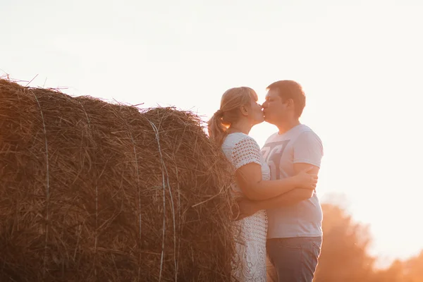 Love story man och kvinna på bakgrunden av höstackar solen — Stockfoto