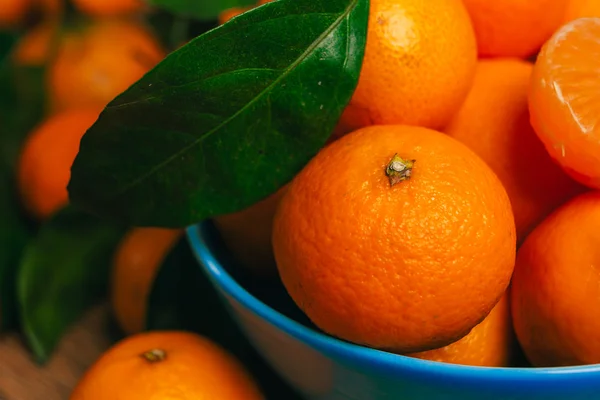 Muchas naranjas frescas de mandarina en un tazón azul de cerca —  Fotos de Stock