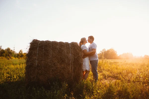 Liebesgeschichte Mann und Frau im Hintergrund der Heuhaufen-Sonne — Stockfoto