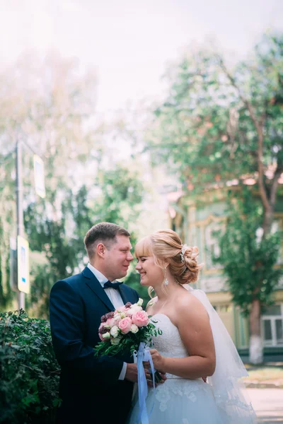 Sposa e sposo sullo sfondo della recinzione del giardino — Foto Stock