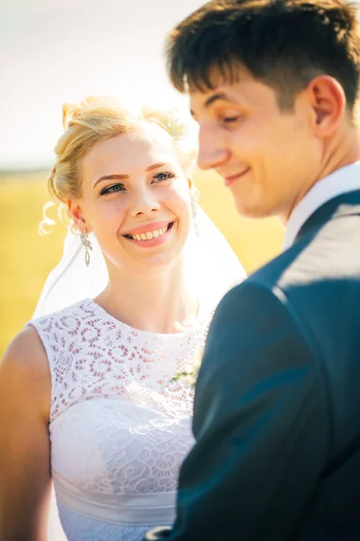 Bruden och brudgummen på bakgrunden av fältet — Stockfoto