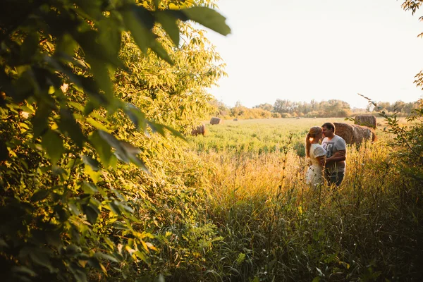 Liebesgeschichte Mann und Frau im Hintergrund der Heuhaufen-Sonne — Stockfoto