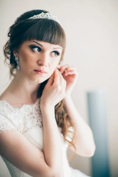 Retrato de una joven novia sonriendo y de pie cerca de la ventana —  Fotos de Stock