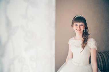 duvara karşı duran bir genç gelin portresi