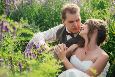 Gelin ve damat bir lavanta arka plan üzerinde dinlenme portresi