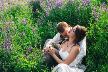 Gelin ve damat bir lavanta arka plan üzerinde dinlenme portresi