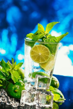 mojito limon ve nane buz küp yakın çekim kırmızı saman ile mavi arka plan üzerinde bardak