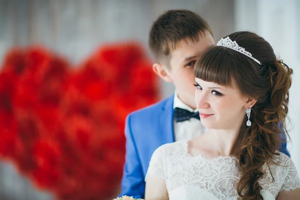 Jeune marié embrasser la mariée dans un studio intérieur — Photo