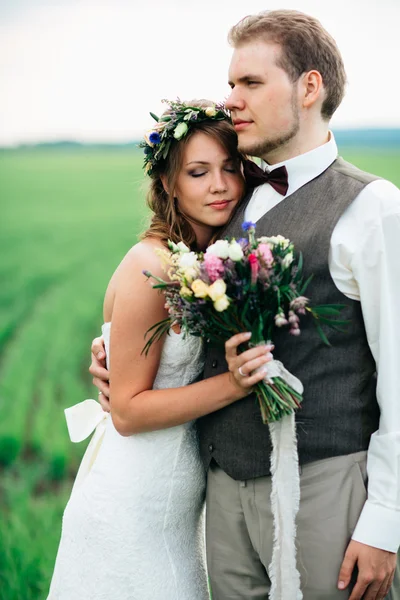 Portrait de la mariée et du marié avec un bouquet sur le champ vert — Photo