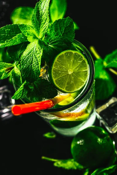 Glas mojito med lime och mint ice cube närbild rött sugrör — Stockfoto