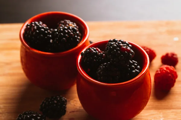 Blackberries in a cup on blurred background of wooden planks — Stock Photo, Image