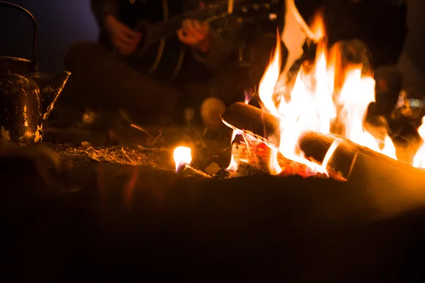 Mann spielt Gitarre und Frau über das Feuer am Sternenhimmel — Stockfoto