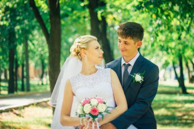 Gelin ve damat parkın arka planında.