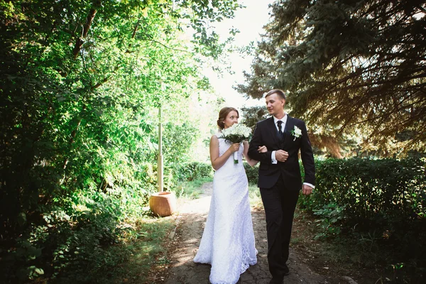 Pár nevěsta a ženich na pozadí parku — Stock fotografie