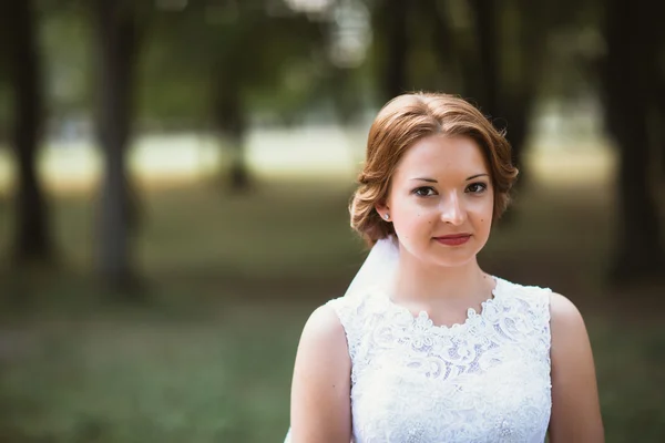 Portrét mladé nevěsty na pozadí park — Stock fotografie