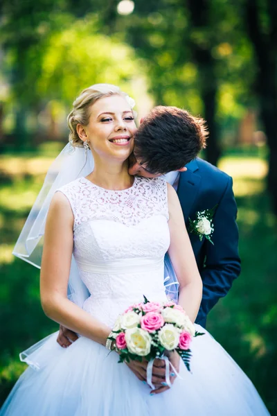 Portrét nevěsty a ženicha na pozadí parku uličky — Stock fotografie