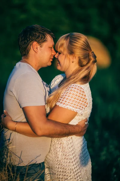 История любви мужчина и женщина на фоне стога сена солнце — стоковое фото