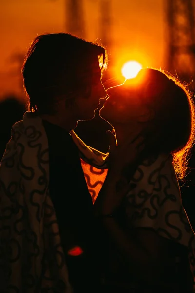 Cara e a menina estão de pé contra o pôr do sol em uma planície — Fotografia de Stock