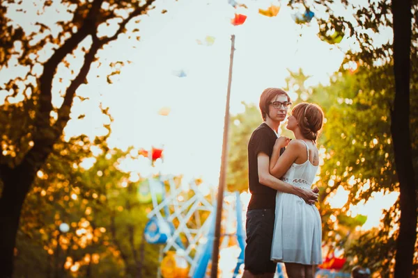 Gars et la fille étreignant à fond d'amusement — Photo