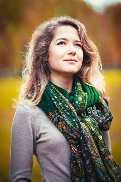 Ritratto di giovane ragazza con foulard verde sullo sfondo del parco autunnale — Foto Stock