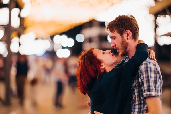 对幸福的夫妇拥抱、 亲吻的晚上上光的花环 — 图库照片
