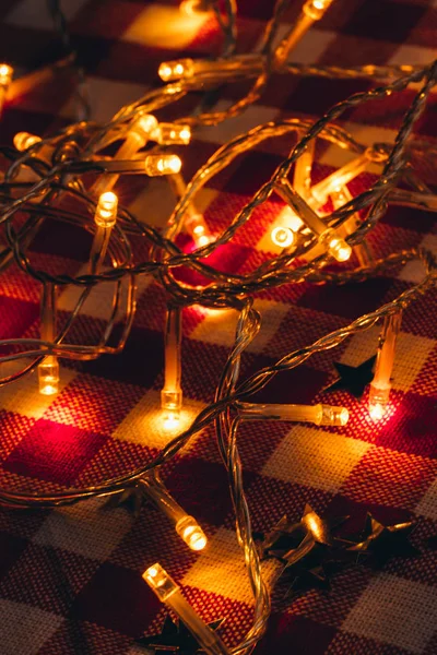 Garland lights in the background of a checkered tablecloth — Stock Photo, Image