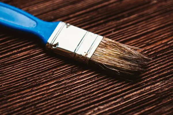 brush to paint on a dark wooden background
