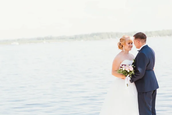 Невеста и жених на фоне реки — стоковое фото